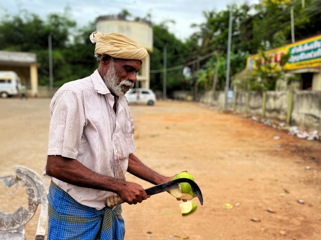 Man cutting coconut in South India